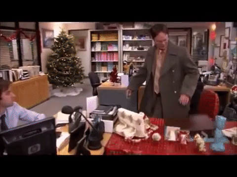 Dwight Schrute from The Office sitting on gift wrapped chair only for it to collapse